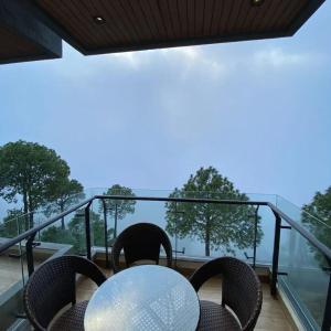 a table and chairs on a balcony with a view at Park Ridge Hotel Serviced Apartments - Executive Apartment in Murree