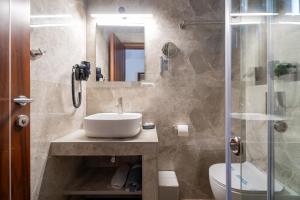 a bathroom with a sink and a shower at Meliton Inn Hotel & Suites by the beach in Neos Marmaras +82 photos