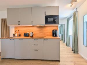 a kitchen with white cabinets and a counter top at HabeDere Apartments Allgäu in Obergünzburg