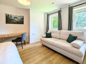 a living room with a couch and a desk at HabeDere Apartments Allgäu in Obergünzburg