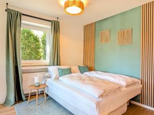a bedroom with a large bed in front of a window at HabeDere Apartments Allgäu in Obergünzburg