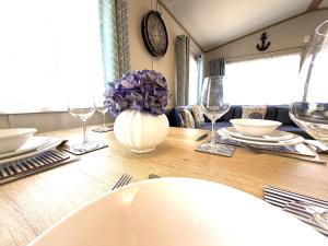 a dining room table with a vase of purple flowers at Gordy's Nook in Scarborough