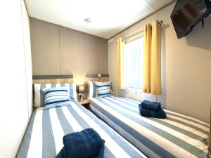 two twin beds in a room with a window at Gordy's Nook in Scarborough