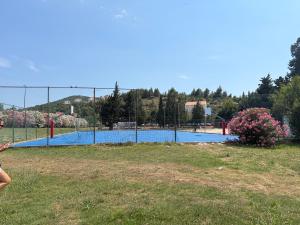 a person standing in front of a tennis court at Apartment Biserka in Cavtat