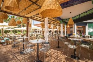 a restaurant with tables and chairs and umbrellas at SOL by Meliá Oasis Marrakech - All Inclusive in Marrakesh