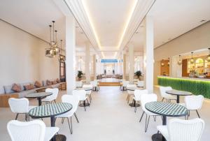 a waiting room with tables and white chairs at SOL by Meliá Oasis Marrakech - All Inclusive in Marrakesh