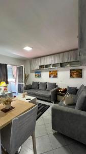 a living room with couches and a table at Cozzy Studio Flat in Tirana
