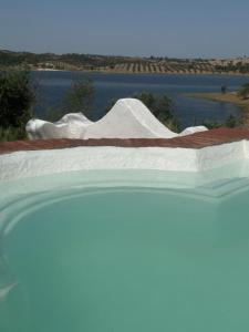 a bed with a view of a body of water at Herdade Monte da Tapada in Alqueva