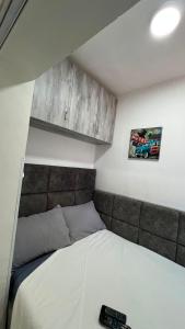 a bedroom with a bed with a remote control on it at Cozzy Studio Flat in Tirana