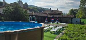 a swimming pool with chairs and american flags in a yard at Къща за гости ЧЕРИ in Tryavna