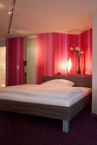 a bedroom with a large bed with pink curtains at B&B Appartements Bischof & Bürk GbR in Tuttlingen