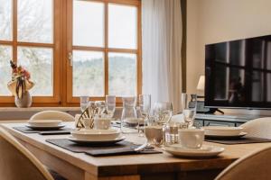 a wooden table with glasses and plates and a television at Urlaub am Schafhof in Rimbach