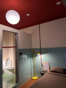 a bedroom with a bed and a toilet and a lamp at 75 Staytion in Bien Hoa