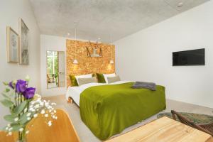 a bedroom with a green bed and a couch at Vilcon Hotel & Konferencegaard in Slagelse +46 photos