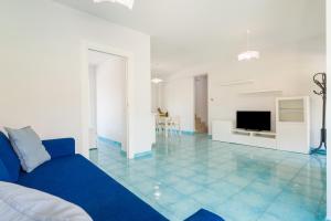 a living room with a blue couch and a tv at CalaDune Villas in Pizzo