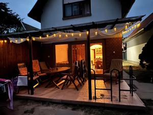 a patio with a table and chairs and lights at Füzesem Apartman in Békésszentandrás