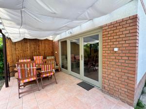 a patio with a table and chairs and an umbrella at Füzesem Apartman in Békésszentandrás