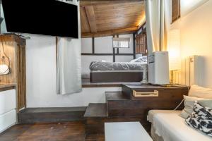 a living room with a couch and a tv at Cabañita rústica con piscinas in Cambre