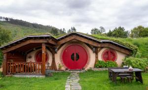 a house with a grass roof and red doors at Mi Tesoro in Viveiro
