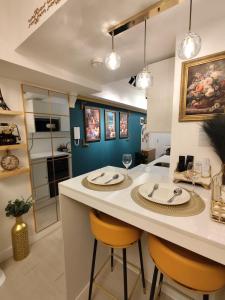 a kitchen with a island with two chairs and a counter top at CA Smart Staycation at Azure North in Lagundi