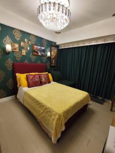 a bedroom with a bed and a chandelier at CA Smart Staycation at Azure North in Lagundi +14 photos