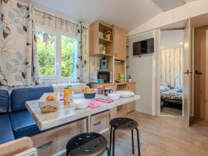 a small kitchen with a blue couch and a table at Camping Le Dolium in Laudun