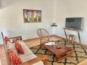 a living room with a couch and a table and a tv at Villa Soafeno in Antsiranana
