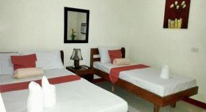 a room with two beds and a mirror at AGM Beachfront Resort in Donsol +69 photos