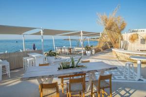 a table and chairs and an umbrella on the beach at SOL by Meliá Marina Beach Crete in Gouves