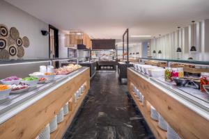 a kitchen with a buffet line with food on display at SOL by Meliá Marina Beach Crete in Gouves