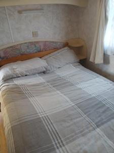 a bed with two pillows on it in a bedroom at Mobile home in Liscannor