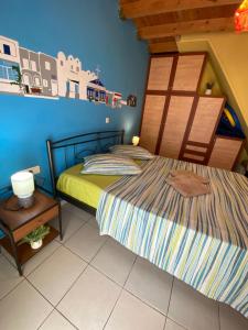 a bedroom with two beds and a blue wall at Roxys sea view Santorini Monolithos in Santorini