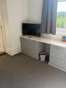 a room with a desk with a tv and a window at The Rising Sun in Rogerstone +19 photos