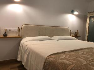 a bed in a bedroom with two lights on the wall at Entre Micelios in Vinuesa +4 photos