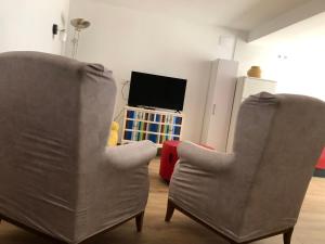 two chairs in a living room with a tv at Entre Micelios in Vinuesa
