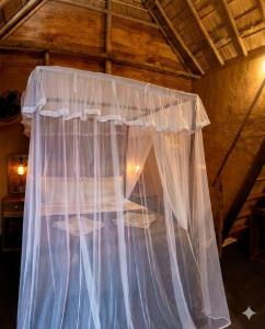 a bed with a net curtain in a room at Blue Mountain Cabana in Ella