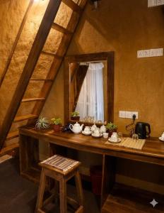 a room with a table with a mirror and a counter with tea pots at Blue Mountain Cabana in Ella