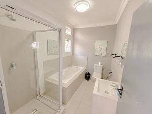 a bathroom with a shower and a tub and a sink at Amoris on Anderson in Pretoria