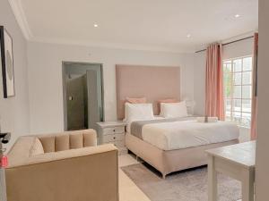 a bedroom with a bed and a couch and a chair at Amoris on Anderson in Pretoria