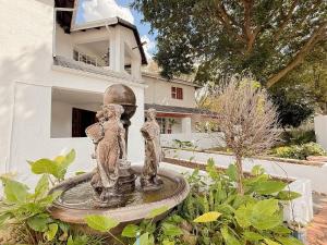 a statue in a garden in front of a house at Amoris on Anderson in Pretoria