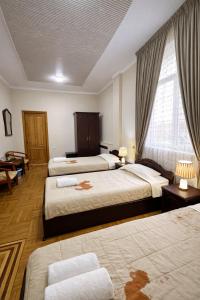 a hotel room with two beds and a window at Hotel Latif Samarkand in Samarkand