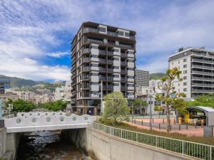 a bridge over a river in a city with buildings at Atami Hotel Nagisakan in Atami