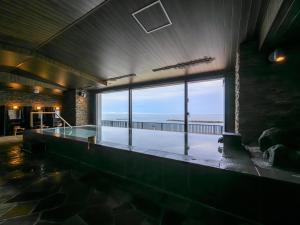 a swimming pool with a view of the ocean at Atami Hotel Nagisakan in Atami