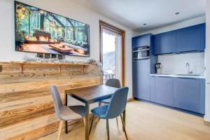 a kitchen with blue cabinets and a table and chairs at Edelweiss Lodge in Morzine