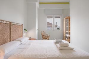 a white bedroom with a large bed with two scales on it at Raízes 22 - Apartamento 5 in Puebla de Don Fadrique +31 photos