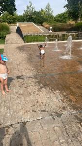 a child playing in a fountain in a park at Ferme Beauchêne in Laigné-en-Belin