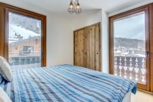 a bedroom with a bed and a large window at Edelweiss Lodge in Morzine
