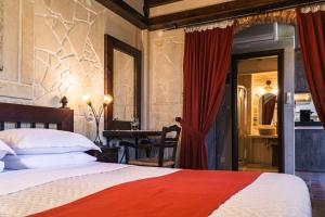 a bedroom with a large bed and a table with a desk at Terra Minoika Boutique Resort in Kato Zakros