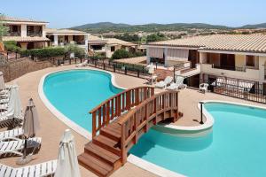 a large swimming pool with a wooden bridge and chairs at I girasoli in Villasimius