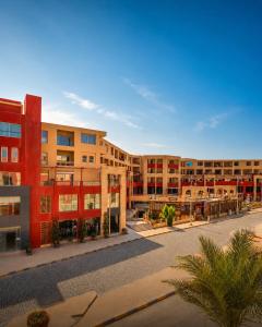 an apartment building with a courtyard with palm trees at Alhambra First Avenue in Hurghada